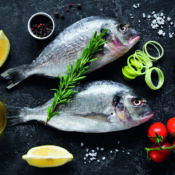 fresh,uncooked,dorado,or,sea,bream,fish,with,lemon,slices,