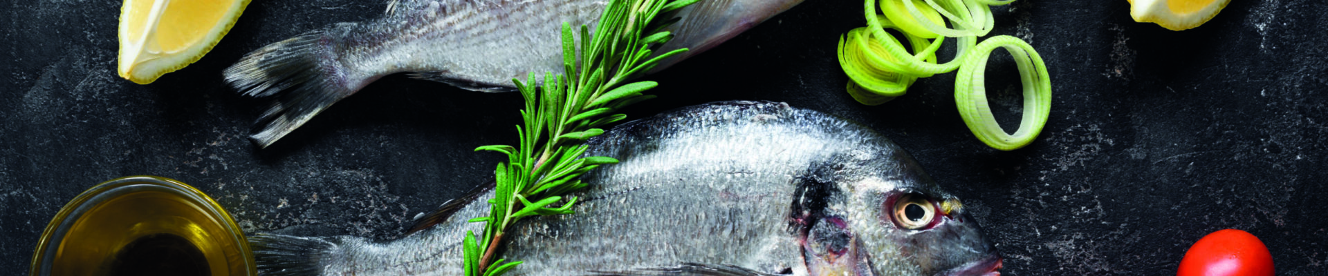 fresh,uncooked,dorado,or,sea,bream,fish,with,lemon,slices,