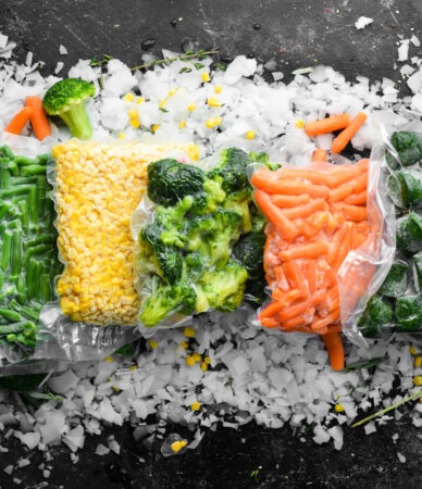 assortment of frozen vegetables on ice. stocks of food. top view. free space for your text.