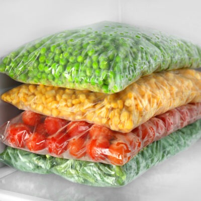 bags with frozen vegetables in refrigerator, closeup
